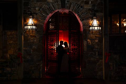 Under a starlit December sky, Laura and Lee stand embraced outside Bill Miller’s Castle, with its glowing windows and twinkling lights adding a romantic, magical ambiance.'