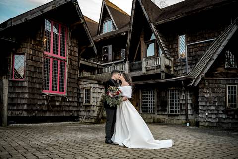 Laura and Lee share a tender kiss on the grand staircase of Bill Miller’s Castle, surrounded by its dramatic stone walls and glowing chandeliers, creating a moment straight out of a storybook.'