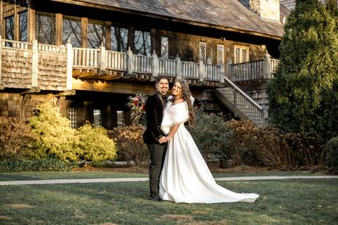Framed by the towering castle doors, Laura and Lee hold each other close, their love illuminated by the soft winter light that highlights the timeless elegance of the venue.'