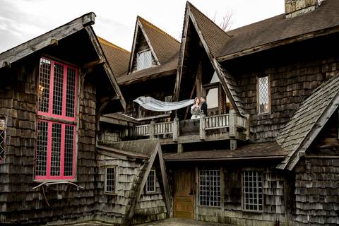 Laura’s veil catches the crisp December breeze as she stands hand in hand with Lee, the dramatic movement adding a touch of ethereal beauty against the majestic backdrop of Bill Miller’s Castle.'