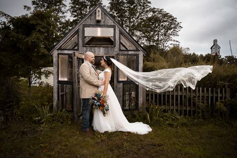 Candid moment of the couple laughing beside a vintage barn at Angel and Anchor Farm — perfect for a rustic wedding in Connecticut.'