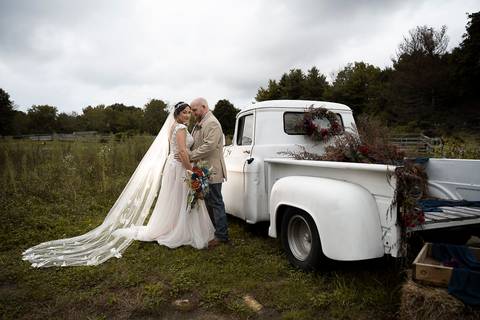 Romantic cowboy-style wedding photo of the bride and groom walking through a sunlit pasture at Angel and Anchor Farm in Sterling, CT.
Vanessa Trettel Photography'