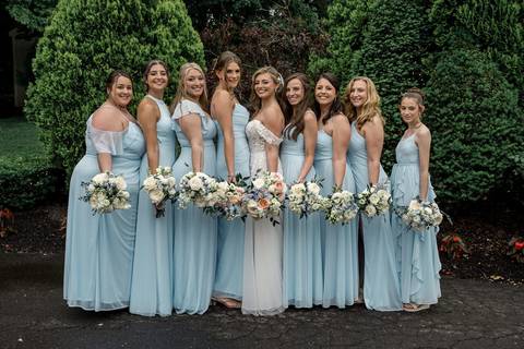 Bridesmaids in soft blue dresses and groomsmen in classic suits — the perfect color harmony for a summer wedding.'