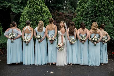 Bridesmaids in soft blue dresses and groomsmen in classic suits — the perfect color harmony for a summer wedding.'