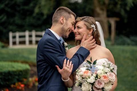 The newlyweds share a laugh as their veil catches the breeze, symbolizing the lightness of their love.'
