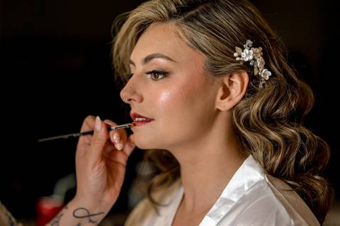 Katelyn smiles softly as sunlight pours through the window, capturing the calm anticipation before walking down the aisle.'