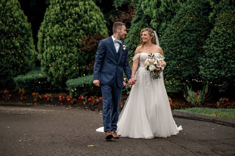 The newlyweds share a laugh as their veil catches the breeze, symbolizing the lightness of their love.'