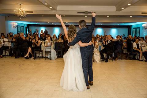 Their first dance as husband and wife, surrounded by glowing lights and smiling faces.'