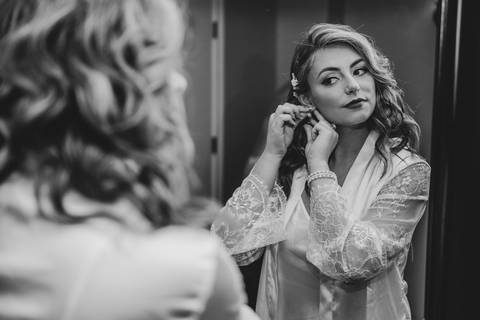 Delicate details of Katelyn’s jewelry and bouquet resting beside her wedding invitation — timeless and romantic.'