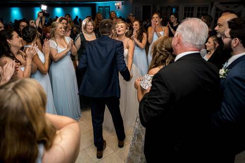 A wide shot of the entire ballroom glowing with happiness, movement, and celebration.'