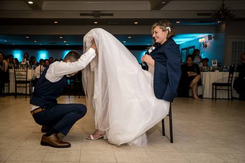 Casey playfully removes the garter as the crowd cheers and laughs.'