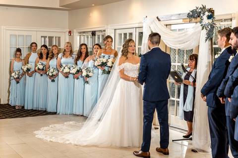 The couple exchanges vows beneath The Woodwinds’ garden arch, surrounded by blooming greenery and heartfelt emotion.'