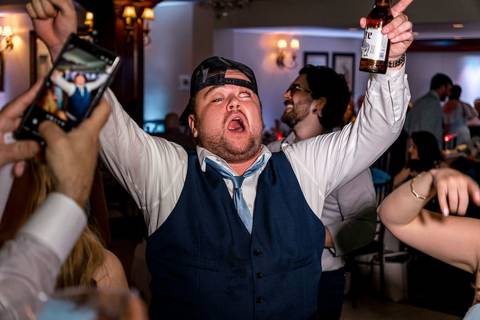 A candid moment of guests singing along and dancing together, capturing the night’s pure joy.'