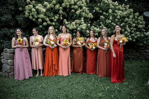The magical first kiss surrounded by cheering guests, rustic wood chairs, and a golden summer sunset at this Connecticut farm wedding.'