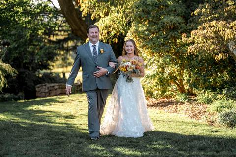 The bride’s breathtaking entrance in her wedding gown, radiating elegance as guests stand in admiration at this CT farm ceremony.'