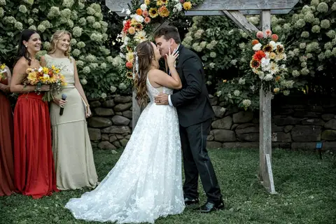 A romantic first kiss as husband and wife, set against the rustic charm of Gastler Farm’s fields on a sunny CT afternoon.'