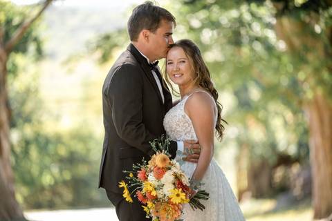 Stunning artistic wedding portrait of the couple framed by Gastler Farm’s rustic barn doors and golden summer light.'