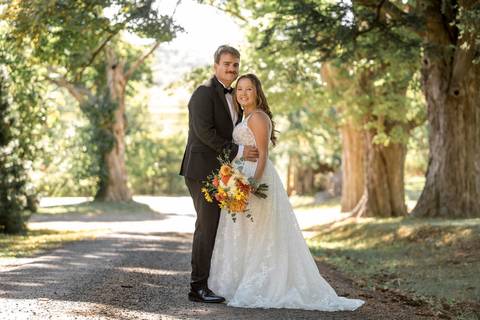 Stunning artistic wedding portrait of the couple framed by Gastler Farm’s rustic barn doors and golden summer light.'