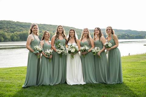 The bride stands with her bridesmaids in green dresses, holding white bouquets. The color palette pops beautifully against the natural surroundings.
Vanessa Trettel Photography'