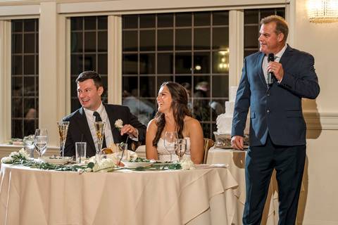 The bride’s father gives a speech, holding the microphone with emotion. His expression reflects pride, love, and nostalgia.
Vanessa Trettel Photography'