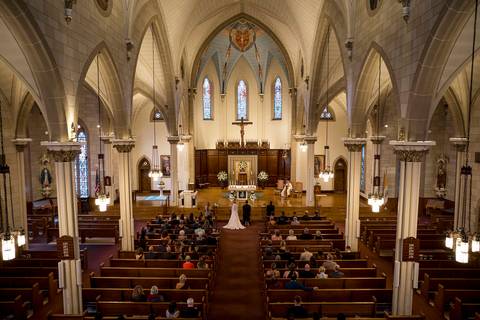 he bride walks down the aisle with her father, sunlight streaming through stained glass. Her expression is a mix of excitement and emotion, while her father holds her arm proudly, creating a timeless and deeply touching moment.
Vanessa Trettel Photography'