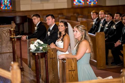 A wide view of the church reveals its grand architecture, glowing softly with natural light. Guests fill the pews, creating a beautiful contrast between the sacred space and the warmth of shared emotion.
Vanessa Trettel Photography'