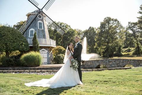 The newlyweds walking hand-in-hand across the beautiful Aqua Turf Club grounds in Plantsville, CT. Perfect backdrop for a summer wedding.'