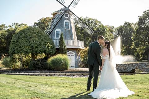 The newlyweds walking hand-in-hand across the beautiful Aqua Turf Club grounds in Plantsville, CT. Perfect backdrop for a summer wedding.'