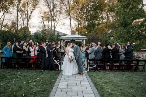 Newlyweds kissing as guests watch during outdoor ceremony exit at Nuzzo’s Farm by Vanessa Trettel, CT Wedding Photographer serving NY'