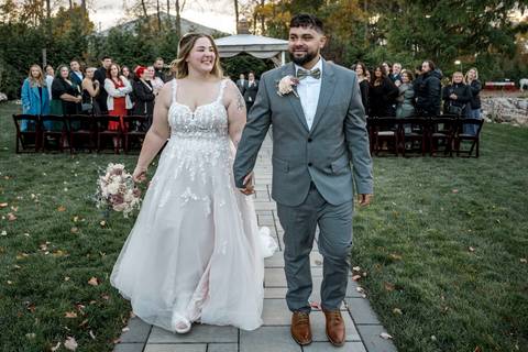 Couple walking away together with guests in the background at Nuzzo’s Farm by Vanessa Trettel, CT Wedding Photographer serving NY'