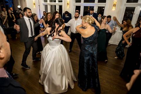 Traditional Bosnian money dance at Whitby Castle, guests throwing money to celebrate the couple, cultural wedding photography by Vanessa Trettel Photography.'
