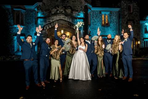 Epic wedding party group photo outside Whitby Castle at night, using flash to light up the venue, photo by Vanessa Trettel Photography.'