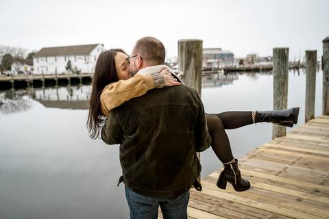 Amelia and Kenneth standing by the docks with historic sailing ships and a gray sky.
Vanessa Trettel Photography
engagement photo at Mystic CT'