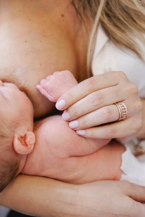 detalhe da mão do bebê enquanto mama'