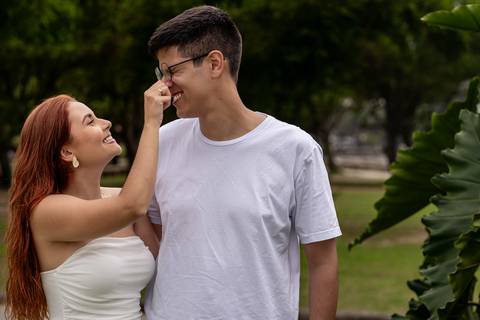 Júlia toca carinhosamente o rosto de Leonardo durante ensaio pré wedding nos jardins do MAM.'