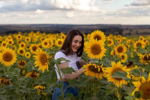 mulher sorrindo no campo de girassol em ensaio fotografico em uberlandia thiagomoon'