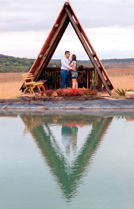 casal em ensaio fotográfico na capela com reflexo na agua'