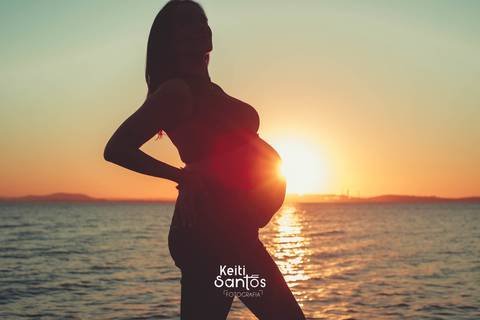 Silhueta de mulher gravida, rio guaíba ao fundo'