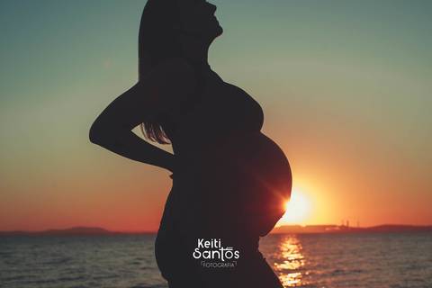 Silhueta de mulher gravida, rio guaíba ao fundo'