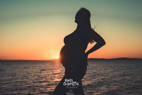 Silhueta de mulher gravida, rio guaíba ao fundo'