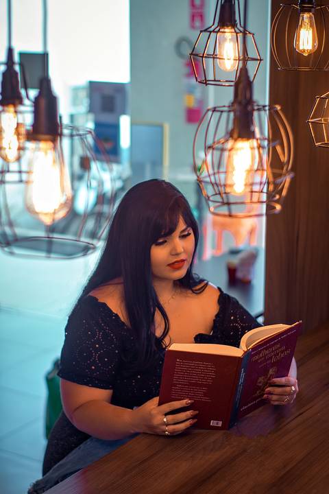 ensaio fotografico gordinha em cafeteria com livros'