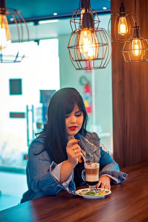 ensaio fotografico gordinha em cafeteria com livros'