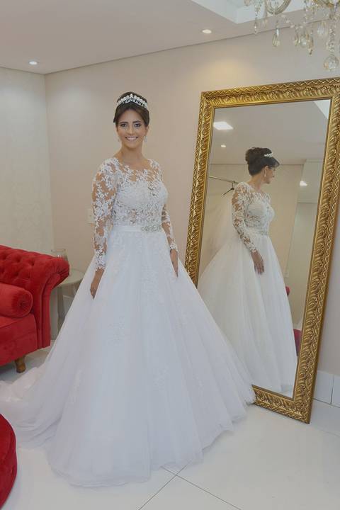 Noiva posando ao lado de um espelho do tamanho dela'