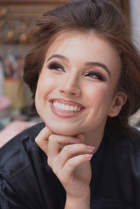 make-off sorrindo com a mão no queixo'