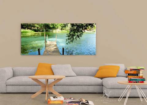 Ambiente de uma sala com um quadro em canvas sob o sofá'