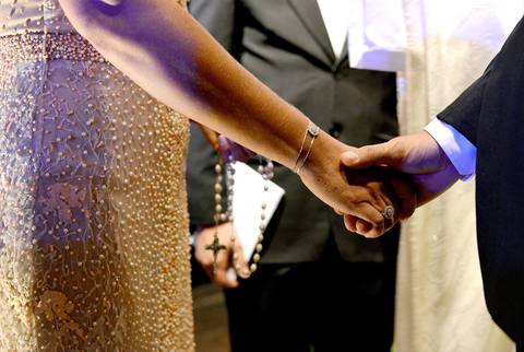 Foto em cor - mãos do casal unidas'