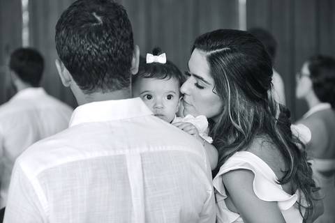 foto em preto e branco da mãe beijando sua bebê durante o batizado'
