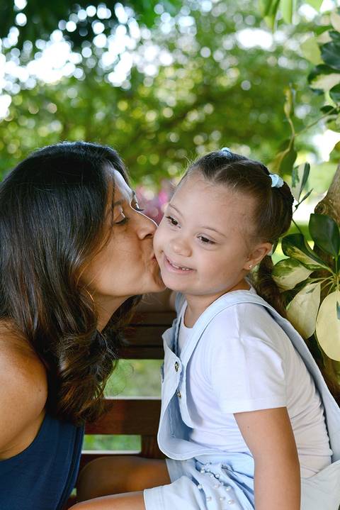 Mãe beija filha com amor'