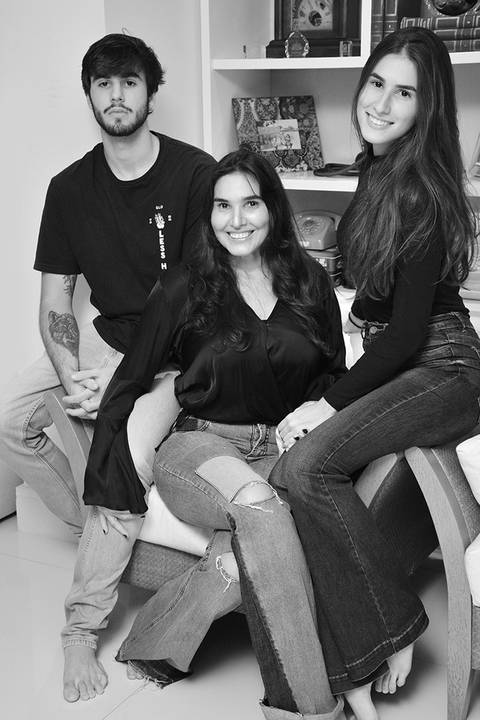 Mãe e filhos adultos posam em foto pb'