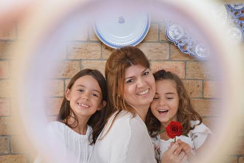 Mãe e filhas em cena de descontraída'